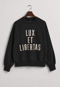 Felpa nera con maniche raglan. Presenta il testo "LUX ET LIBERTAS" in crema. Collo e polsini a costine, texture morbida e vestibilità casual.