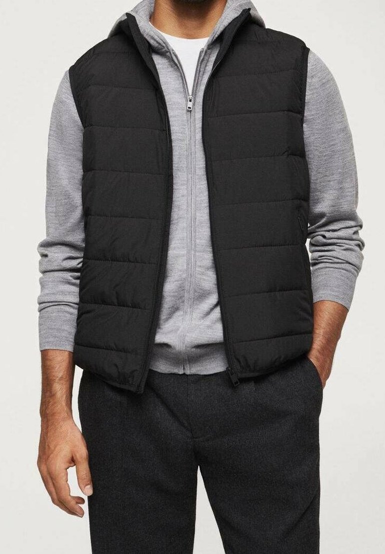 Schwarze Steppweste mit gestepptem Design, getragen über einem grauen, zip-up Pullover. Die Weste ist ärmellos, hat einen Stehkragen und einen Reißverschluss.