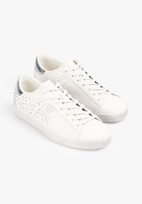 Witte sneakers met een gestructureerde zool, metalen zilverkleurige hielaccent en studded ontwerp aan de zijkanten. Vetersluiting. Gladde leren afwerking.