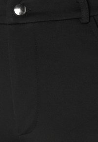 Svarta byxor med en smidig textur, som har knäppning med metallknapp, slim-fit design och tydliga sömdetaljer fram.