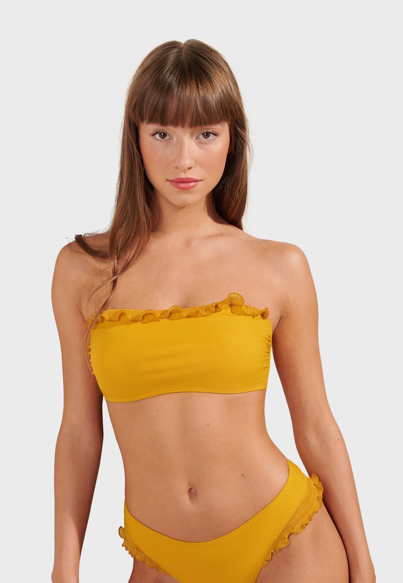 Yellow bikini set featuring a strapless top with ruffle trim and matching high-waisted bottoms with similar ruffled accents. Smooth texture.