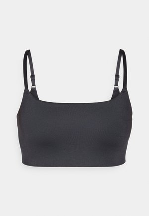 Črna bralette z brezšivnim dizajnom, tankimi nastavljivimi naramnicami in mehkobo tekstilnega materiala za udobje in oporo.