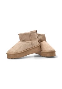 Botines de gamuza color tostado con punta redondeada y parte superior suave, que presentan una suela texturizada y detalles de costura mínimos.