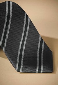 Schwarze gestreifte Krawatte mit diagonalen silbernen Streifen, strukturiertes Gewebe mit gewebtem Muster, zulaufend zu einem spitzen Ende.
