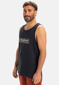 Marinblå tanktopp i bomull med rund halsringning, med en färgglad logotypdesign i mitten och en avslappnad passform.