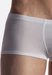 White cotton boxer briefs with a smooth texture and elastic waistband, feature a close fit and minimal stitching detail for comfort.