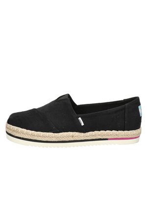 Chaussure espadrille noire sans lacets avec semelle en jute tressé, semelle extérieure en caoutchouc blanc et petite étiquette de marque en tissu sur le côté et le talon.