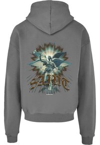 Grå hettegenser med et stort grafisk motiv av en vinget engel som holder en trompet, omringet av eksplosjonsmønstre og ordet "SAINT" i gull.