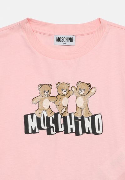 Ροζ παιδικό πουκάμισο με τρεις χαμογελαστές αρκουδάκια πάνω από έντονο κείμενο «MOSCHINO» σε μαύρο και άσπρο.