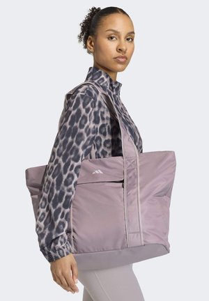 Large purple tote bag made from quilted material, featuring a front zipper pocket and double handles for carrying. Decorative stitching details.