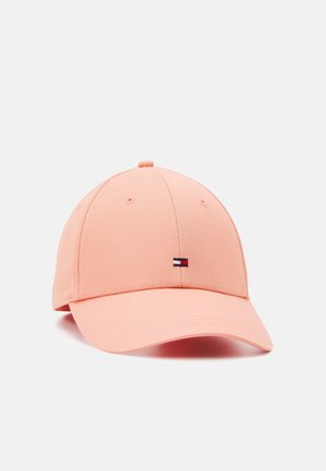 Jasnoróżowa czapka bejsbolowa z małym prostokątnym logo w kolorach czerwonym, białym i niebieskim na środku przodu, z zakrzywionym daszkiem i przeszytymi otworami wentylacyjnymi.