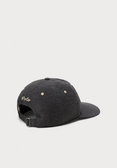Tumehall fliisist nokamüts kumerdatud äärega, reguleeritava rihma ja tagaküljel tikitud "Polo" logoga. Omab heledaid õhutamiseks mõeldud silmuseid.