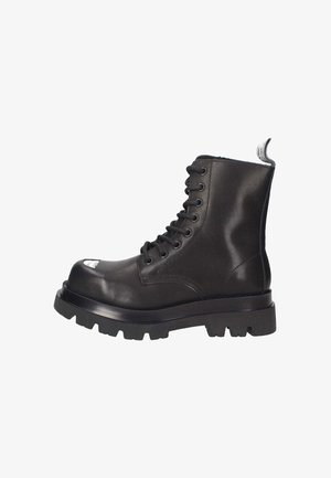 Stivale alla caviglia in pelle nera con punta rotonda, chiusura con lacci e suola robusta. Presenta un tassello per il comando sul retro e dettagli di cucitura sottili.
