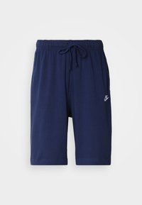 Námořnické modré sportovní šortky vyrobené z měkké látky, s elastickým pasem a šňůrkou a malým bílým logem Nike na boku.