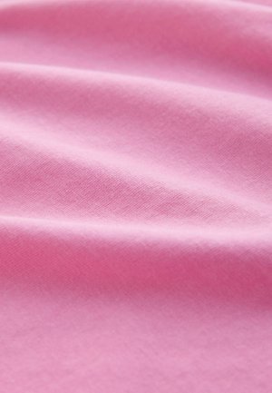 Tissu en coton de couleur rose clair unie, présentant une texture lisse avec de subtiles ondulations et plis, mettant en valeur sa qualité douce et respirante.