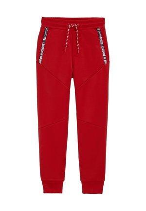 Punaiset verkkarit pehmeästä kankaasta, joissa on vetoketjulliset taskut ja kiristysnyöri vyötäröllä. Ompeleet muodostavat geometrisen kuvion.