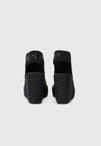 Sandali neri con tacco a cuneo caratterizzati da una suola in stile espadrilla texturizzata e una parte superiore in rete con una fascia nera brandizzata.