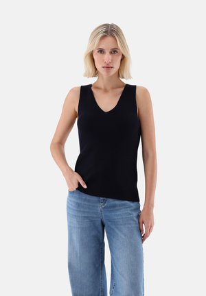 Schwarzes, geripptes, ärmelloses Oberteil mit V-Ausschnitt, kombiniert mit hellblauen, weiten Jeans, die einen lässigen Stil präsentieren.