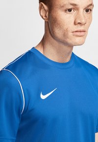 Maglietta sportiva Nike blu a maniche corte. Presenta dettagli bianchi e il logo Nike sul petto. Realizzata in materiale liscio e traspirante.