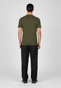 Olivgrünes kurz�ärmliges T-Shirt mit Rundhalsausschnitt, glatter Textur und taillierter Passform, getragen mit schwarzen Hosen, von hinten betrachtet.