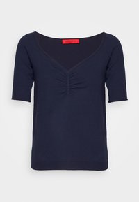 Tmavě modrý top s krátkým rukávem a V výstřihem, se zařasenými detaily na přední straně a hladkou, jemnou texturou. Upravovaný lem.