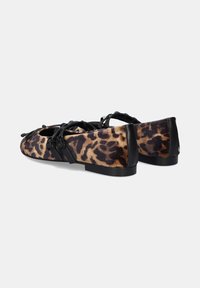 Zapatos planos de estampado de leopardo con ribete negro, textura suave, punta redondeada y detalle de doble correa. Tacón bajo y plantilla acolchada para mayor comodidad.