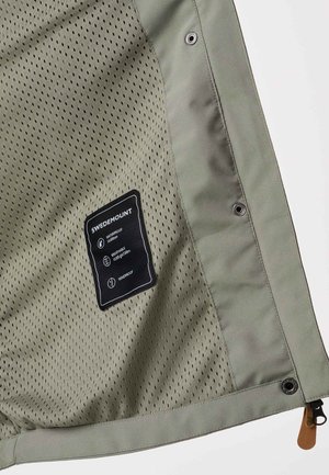 Binnenkant van olijfgroene jas met ademende meshvoering, drukknopen, rits met leren trekker en Swedemount-label met waterdichte en winddichte pictogrammen.