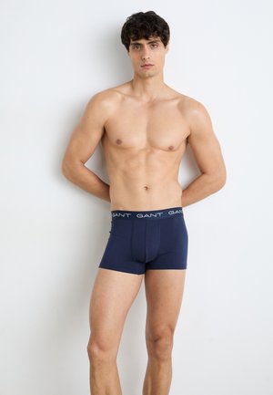 Marineblaue Boxershorts aus weichem Stoff mit einem elastischen Bund, auf dem der Markenname "GANT" in Weiß gedruckt ist.