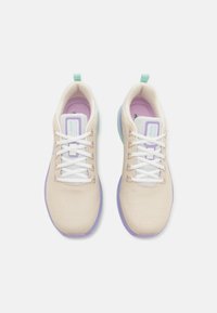 Zapatillas de malla beige con cordones blancos, detalles morados y tirador en verde azulado. Suela suave y forro acolchado. Diseño ligero y transpirable.