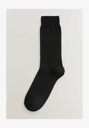 Crna pamučna čarapa s naboranim rubom, glatkom teksturom, istaknutim šavom na prstu i srednje visine. Klasični dizajn pogodan za raznu obuću.