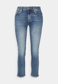 Jeans de mezclilla azul claro con un ajuste Slim, que cuentan con cinco bolsillos, remaches de cobre y una textura ligeramente descolorida. Terminados en los tobillos.
