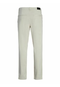 Pantalones beige de corte recto, fabricados en algodón. Consta de dos bolsillos traseros y una cinturilla con un acento en negro. Textura suave.
