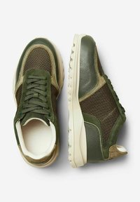 Baskets vertes avec des détails en mesh et en daim, une semelle rembourrée et un système de fermeture à lacets. Présente une surface texturée et des accents contrastés.