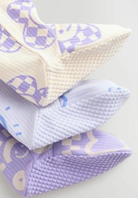 Trois coussins texturés dans des teintes de crème et de lavande, présentant des tissus à motifs et des accents en pointes sur les bords, mettant en avant des designs variés.