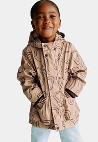 Lysebrune vandtætte jakke med abstrakte sorte mønstre. Har en hætte, forlommer og knaplukning. Velegnet til børn.