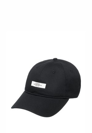 Black cap made of cotton twill with a slightly curved visor. Features a white rectangular label with black text on the front.