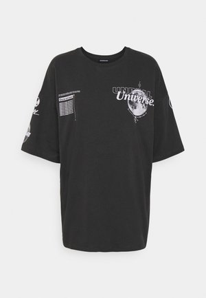 Black oversized t-shirt made of cotton. Features graphic prints including "UNREAL Universe" and various text elements on sleeves.