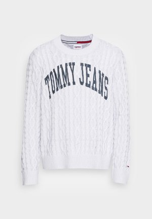 White cable knit sweater with "TOMMY JEANS" text in navy across the chest and small Tommy Hilfiger flag on the left cuff.