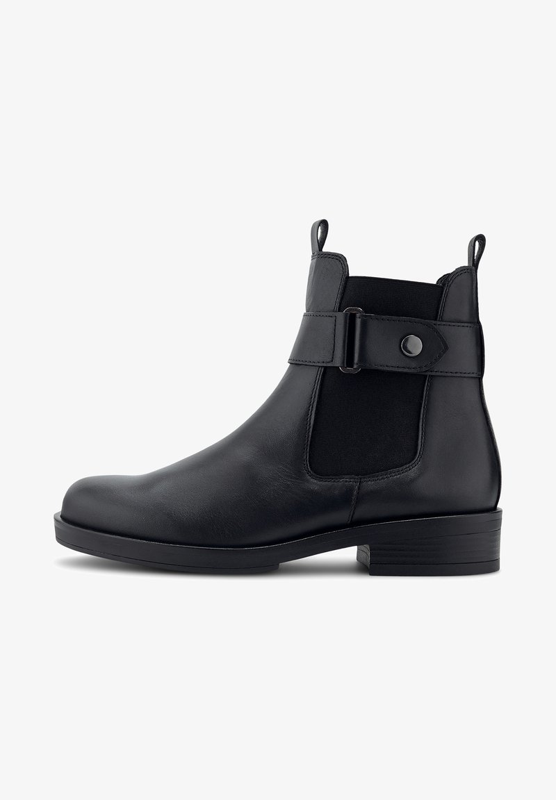 Bottine en cuir noir avec panneau élastique latéral, sangle décorative avec boucle, talon bas empilé, et languettes de traction à l’avant et à l’arrière.