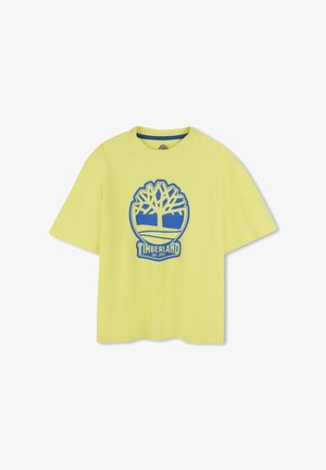 T-shirt in cotone giallo con vestibilità rilassata. Presenta un logo di un albero blu e un design circolare con il testo "TIMBERLAND Est. 1973" nella parte inferiore.