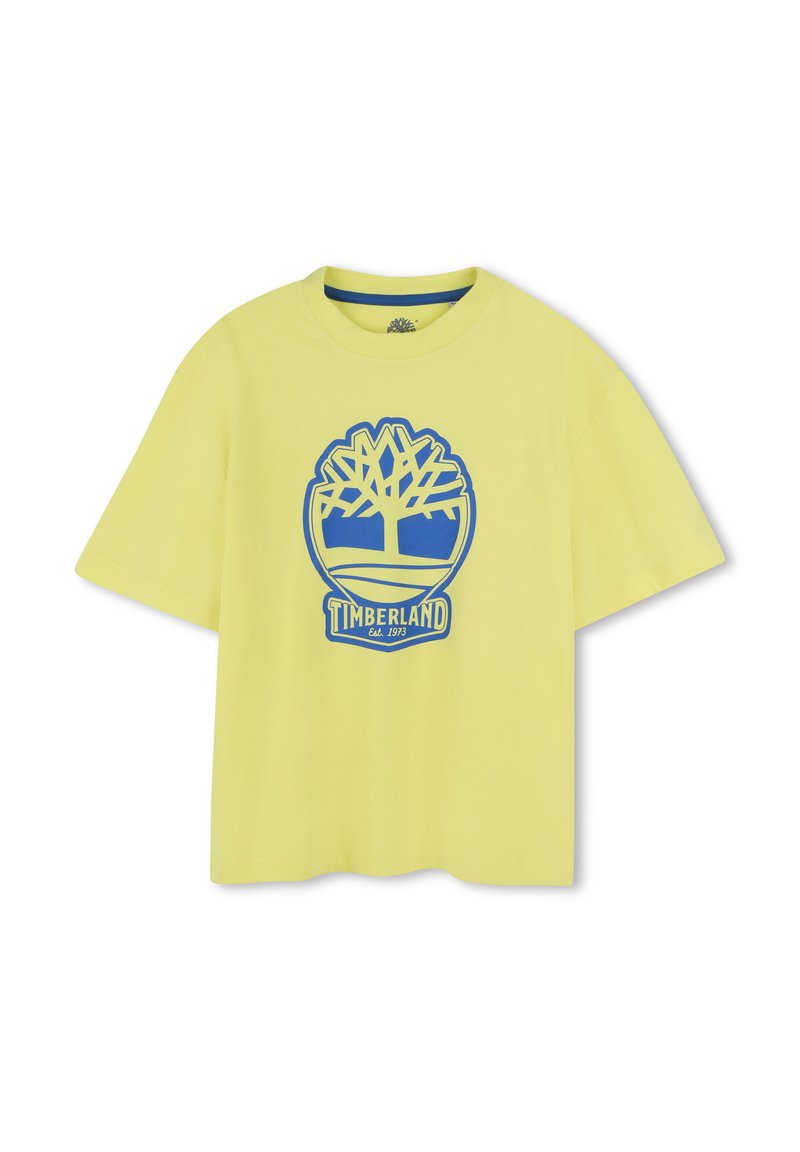 T-shirt in cotone giallo con vestibilità rilassata. Presenta un logo di un albero blu e un design circolare con il testo "TIMBERLAND Est. 1973" nella parte inferiore.