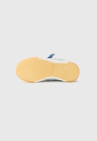 Semelle en caoutchouc texturé de baskets bleu suède. Présente une semelle intermédiaire blanche et un accent en tissu bleu au niveau du talon. Design minimaliste.