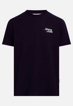 T-shirt noir à manches courtes et col rond avec le texte blanc "Nothing Lasts" sur le côté gauche de la poitrine.