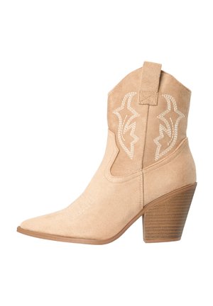 Bota vaquera de ante beige hasta media pantorrilla con tacón bloque apilado y patrones decorativos bordados en blanco en la parte superior del tubo.