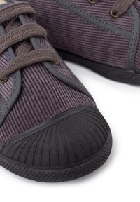 Sneaker in corduroy viola con lacci grigi e suole in gomma. Caratterizzati da una punta rotonda e una superficie testurizzata per una presa migliorata.