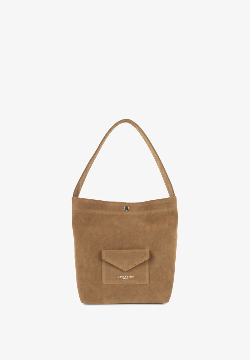 Sac à main en daim marron avec un fond plat, une seule bandoulière et une poche avant avec un rabat. Marque discrète sur le devant.