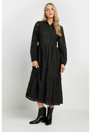 Abito midi in pizzo nero con colletto a bottoni, maniche lunghe e gonna a balze. Presenta motivi floreali intricati e una vestibilità rilassata.