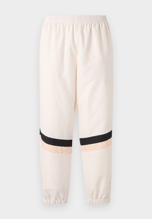 Pantalon décontracté beige clair avec taille et poignets élastiques, avec des rayures horizontales noires et pêche pâle près des genoux.