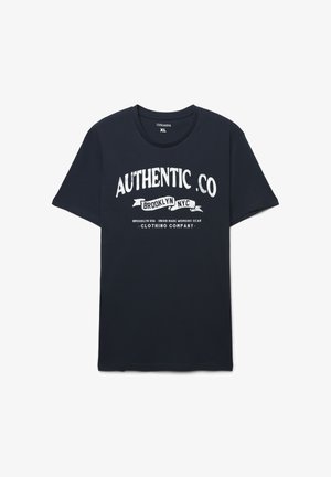 Granatowy bawełniany t-shirt z krótkimi rękawami i okrągłym dekoltem. Przód ozdobiony przetartym białym napisem „AUTHENTIC CO” oraz grafiką. Rozmiar XL.