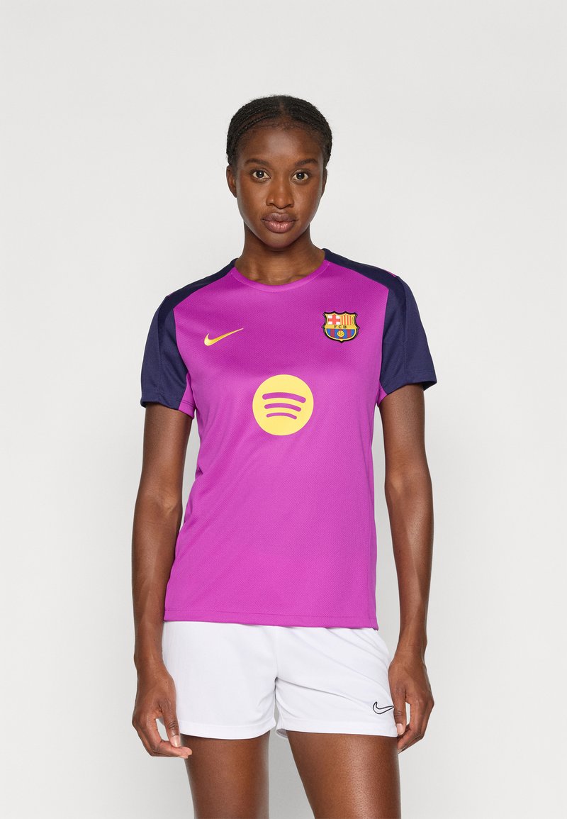 Lilla og marineblå Nike fotballtrøye med korte ermer, med Barça-logo og sirkulær Spotify-logo på forsiden. Kombinert med hvite shorts.
